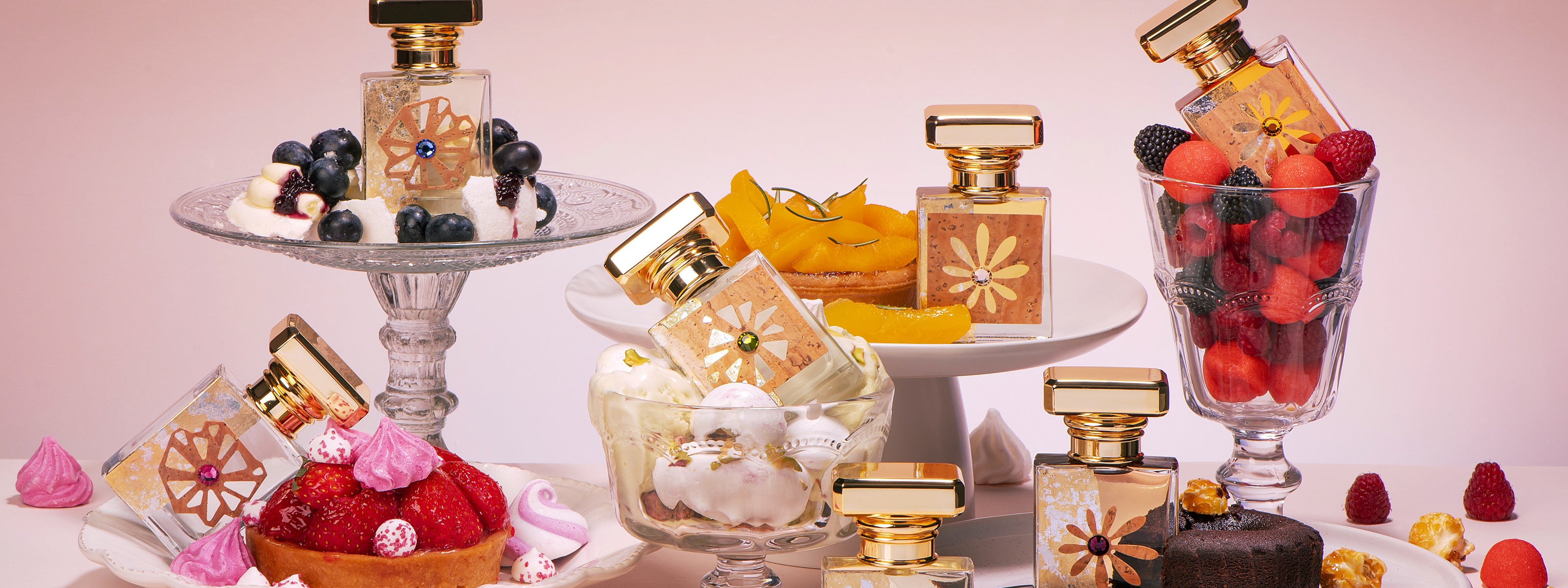 Flacons de la Collection Desserts M.Micallef entourés de pâtisseries, fruits rouges et douceurs gourmandes.